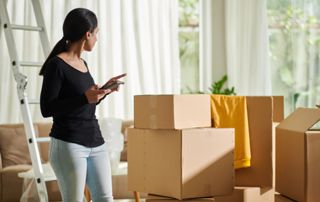 femme en train d'évaluer le volume de ses cartons de déménagement